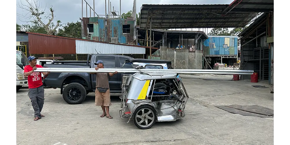 トライシクルにアルミ棒を積み込む。これだけ長い棒が、あのトライシクルに乗るんです