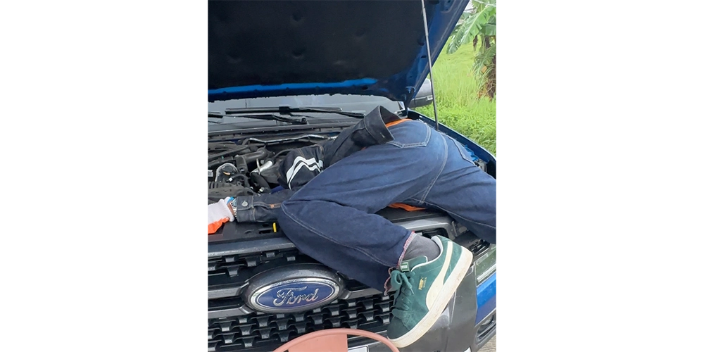 奥深くに挟まった猫を救出中のライアン。
上半身ぜんぶが車の中に。