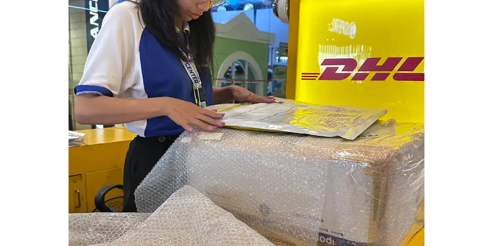 DHLのお姉さんに絵をチェックされた後梱包してもらっている図。